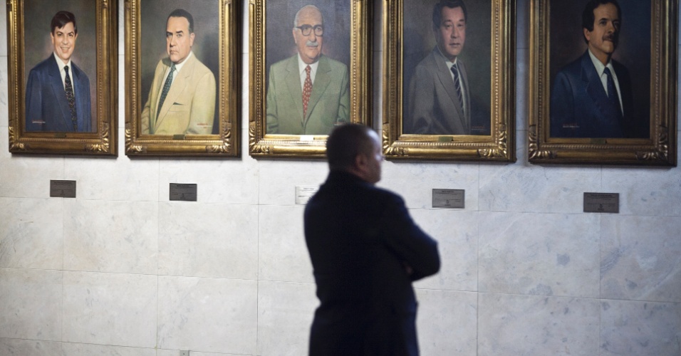 Homem observa quadros de ex-presidentes da Câmara Municipal de São Paulo
