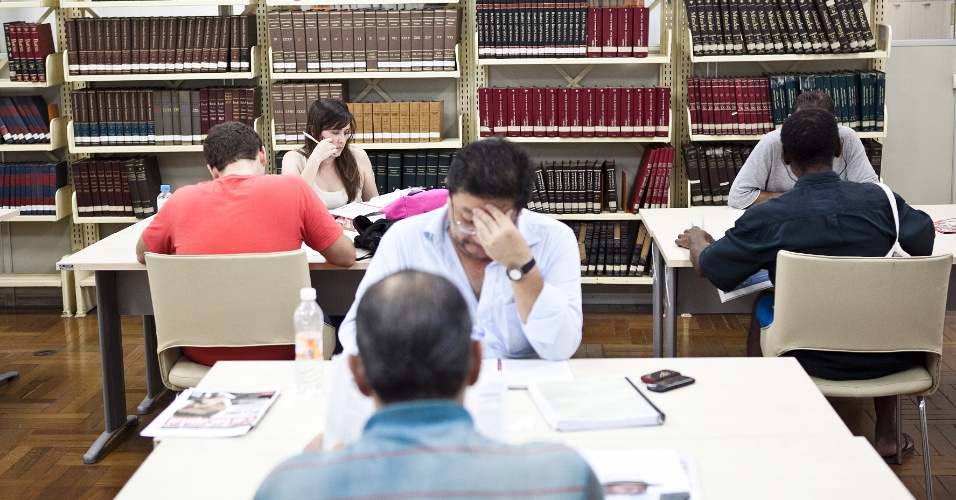 Pessoas consultam livros na biblioteca da Câmara Municipal de São Paulo
