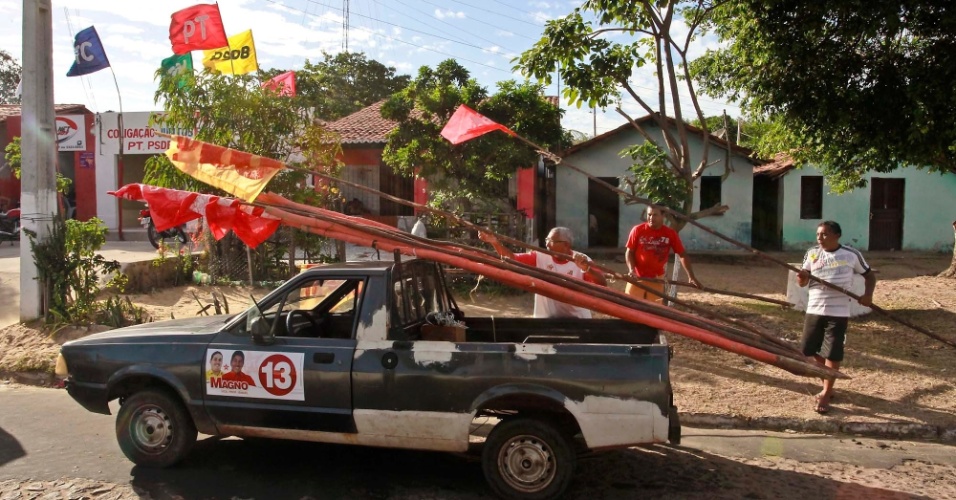 19.set.2012 - Homens carregam carro com bandeiras de candidato em Ilha Grande, no Piauí