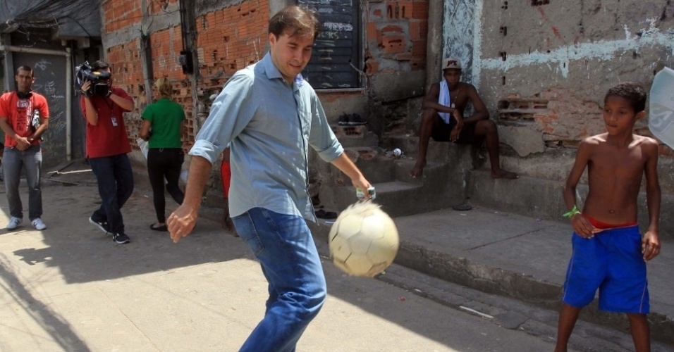 24.set.2012 - O candidato do DEM à Prefeitura do Rio de Janeiro, Rodrigo Maia, bate bola com garoto durante visita ao morro do Tuiuti, na zona norte da capital fluminense