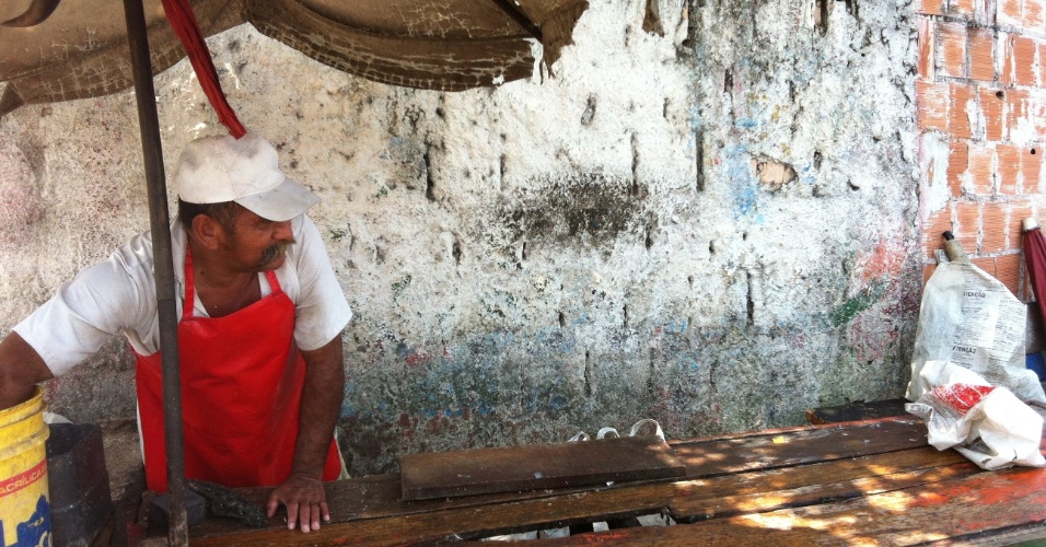 24.set.2012 - Samuel Monteiro, peixeiro, limpa barraca de peixe em rua de Manaus, no Amazonas