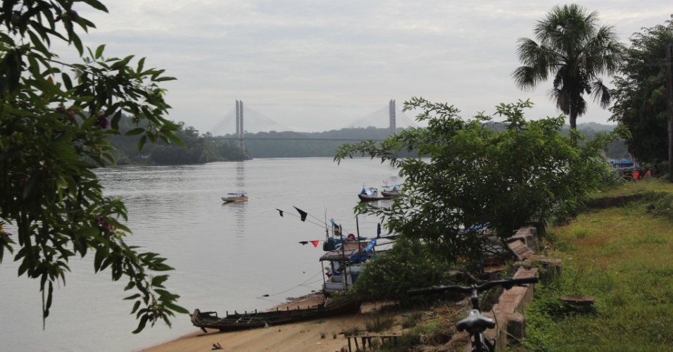 Catraios (pequenos barcos) são vistos com ponte binacional ao fundo, na fronteira entre Oiapoque (AP) e Saint George, na Guiana Francesa