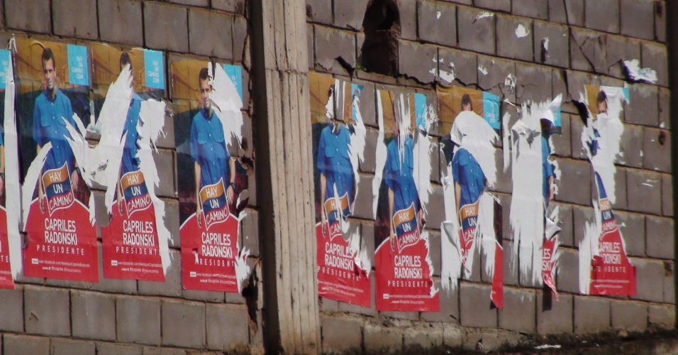 26.set.2012 - Muro tem propagandas rasgadas de Henrique Capriles, candidato à presidência da Venezuela