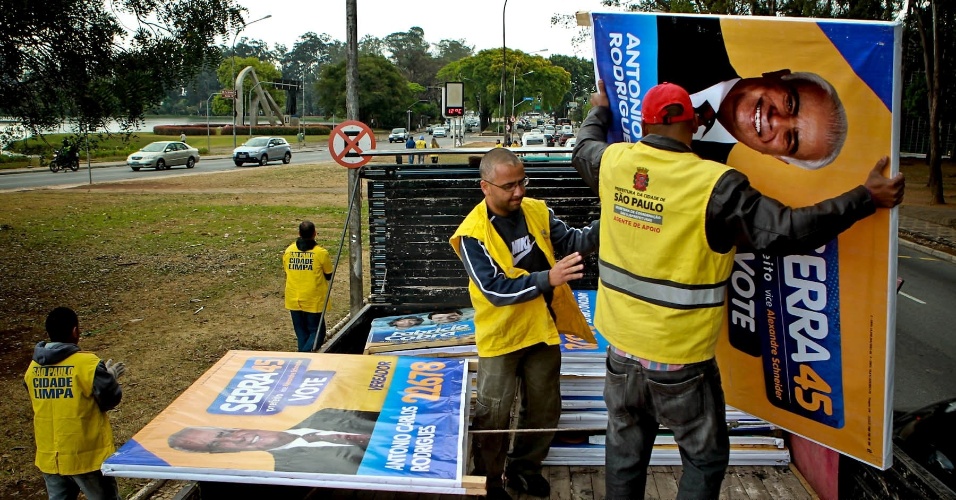 Após serem apreendidos pelos fiscais da prefeitura, os caveletes eleitorais irregulares são empilhados em um caminhão