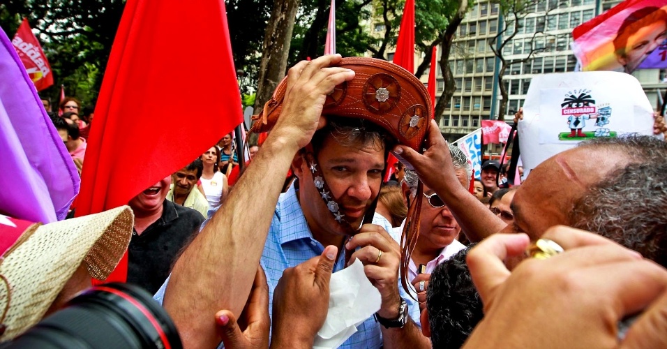 5.out.2012 - Candidato do PT à Prefeitura de São Paulo, Fernando Haddad, fez uma caminhada no centro de São Paulo. Um dos militantes deu um chapéu para o petista colocar