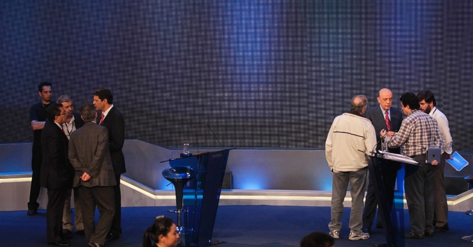 18.out.2012 - Os candidatos à Prefeitura de São Paulo Fernando Haddad (PT) (à esq.de gravata vermelha) e José Serra (PSDB) (à dir. de terno e gravata) falam com assessores durante o intervalo do debate da 