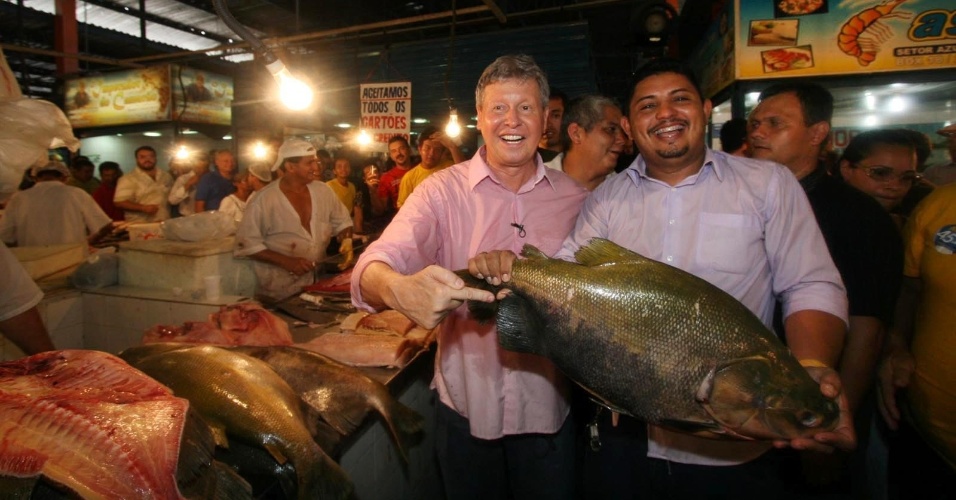 20.out.2012 - O candidato do PSDB à Prefeitura de Manaus, Arthur Virgílio (de rosa), cumprimenta feirantes durante visita a mercado popular na capital amazonense
