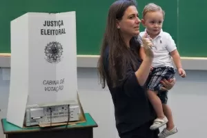 Eleitora acompanhada por criança ao registrar seu voto - Mister Shadow/Estadão Conteúdo